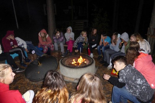 Stimmungsvolle Atmosphäre beim Lagerfeuer nach einem intensiven Tag – ohne Handys – im Wald. Sie sollten Bäume bestimmen und Blaubeeren und Preiselbeeren suchen.